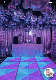 the dance floor is covered in purple and blue disco ball decorations for a wedding reception