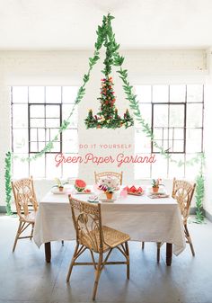 the table is set for two with white linens and greenery hanging from the ceiling