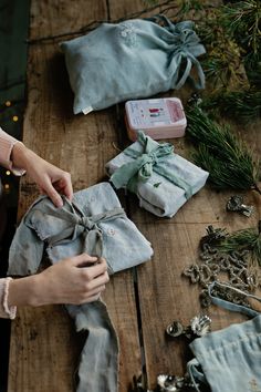 a person is wrapping up some cloth on a wooden table with other items around it