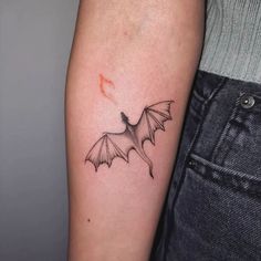 a small bat tattoo on the arm