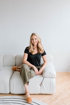 a woman sitting on top of a white couch