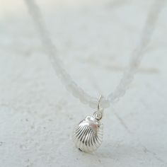 Embrace summer's elegance with our 925 Silver Seashell Pendant Gemstone Beaded Necklace. Crafted with a finely detailed 925 sterling silver seashell pendant, it captures the tranquil allure of the beach. Adorned with natural black rutilated quartz, iridescent white moonstone, and blue crystal beads, this necklace epitomizes seasonal style.The refreshing color palette adds a cooling touch, making it perfect for elevating your summer wardrobe. Versatile enough to complement both casual tees and flowing dresses, this necklace infuses every outfit with coastal charm. Metal: Recycled Sterling Silver Gemstone: White Moonstone,Blue Quartz, Black Rutilated Quartz Necklace Length: 400mm Pendant Dimensions: Length 10-15mm Weight: 4g Sea Salt Blue, Blue Crystal Beads, Rutilated Quartz Necklace, Seashell Pendants, Black Rutilated Quartz, Iridescent White, Gemstone Beaded Necklace, Casual Tees, Coastal Charm