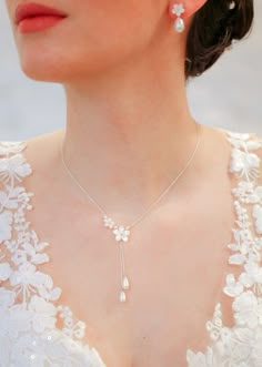 a woman wearing a necklace with pearls on it