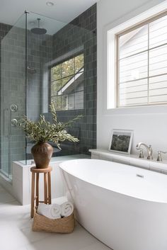 a white bath tub sitting next to a walk in shower