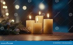 three lit candles sitting on top of a wooden table next to christmas decorations and lights