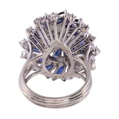 This is part of Chairish’s Fine Jewelry assortment.  Estate marquise diamond & sapphire cocktail ring, circa 1980. This cocktail ring is crafted in 18 karat white gold and features diamonds and sapphires in wire basket style setting. The center .50 carat marquise diamond has I1 clarity and F color. There are 4.25 carat total weight of sapphires and another .85 carat total weight of round diamonds. These diamonds have VS2-I1 clarity and F-H color. This diamond & sapphire cocktail ring is a size 7 Multi-stone Party Rings, Fine Jewelry Style, Fine Jewelry Multi-stone Rings For Party, Elegant Multi-stone Party Rings, Elegant Multi-stone Rings For Party, Fine Jewelry Sapphire Ring For Party, Oval Diamond Ring For Party, Elegant Marquise Cut Multi-stone Cluster Ring, White Gold Sapphire Rings For Party, Oval Fine Jewelry Rings For Party