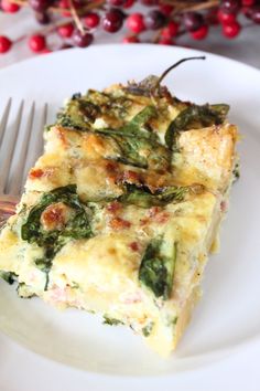 a piece of quiche on a plate with a fork and berries in the background