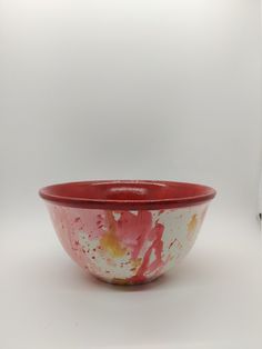 a red and white bowl sitting on top of a table