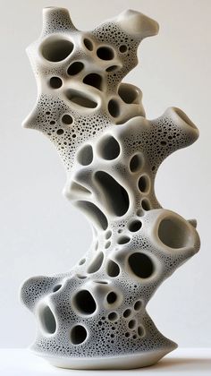 a white sculpture with black dots on it