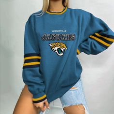 a woman wearing a jacksonville university sweatshirt and ripped shorts