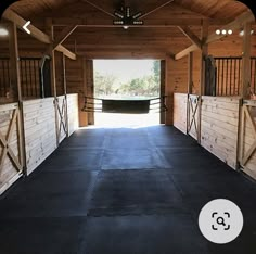 the inside of a horse barn with stalls