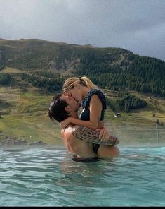 a man and woman are kissing in the water