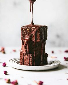 a piece of chocolate cake is being drizzled with chocolate sauce on top