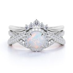 a white opal and diamond ring with an intricate design on the band, set in 18k white gold