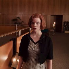 a woman standing next to a wall in a room with wooden walls and flooring