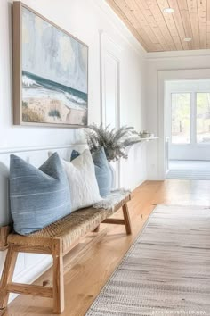 a living room filled with lots of furniture and pillows on top of a wooden bench