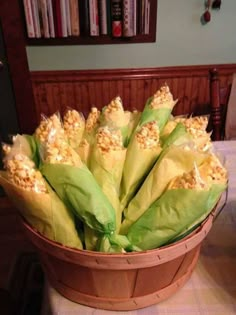 a basket filled with corn sitting on top of a table