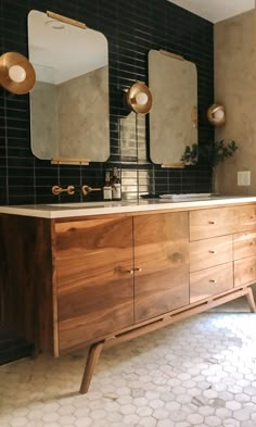 a bathroom with two sinks and mirrors on the wall