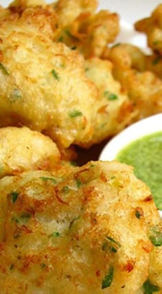 some fried food on a white plate with green sauce