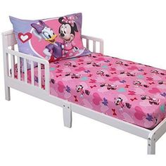 a small child's bed with minnie mouse sheets