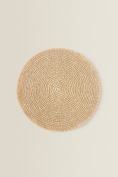 an oval woven placemat on a white surface