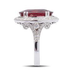 Perfectly deep red, the oval Rubellite that has been bezel-set in 18K White Gold with dazzling diamonds makes a Statement. This beautiful and very rare eye clean gem weighing 9.81 carats has been mined in Brazil. With filigree work at the bottom of the setting, the gem gets just the right amount of light to display its true beauty. Formal Oval Cabochon Ruby Ring With Diamond, Formal Ruby Ring With Diamond And Oval Cabochon Shape, Luxury Oval Ruby Ring For Formal Occasions, Luxury Oval Cabochon Ruby Ring With Center Stone, Formal Red Diamond Ring With Polished Finish, Luxury Red Marquise Ruby Ring, Luxury Marquise Red Ruby Ring, Luxury Red Diamond Ring With Polished Finish, Red Diamond Oval Cabochon Ring