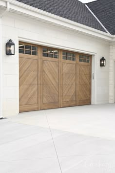 a white house with two brown garage doors