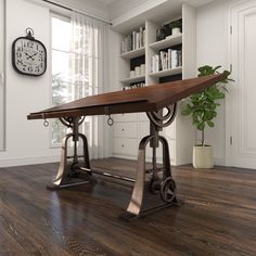 a wooden table sitting on top of a hard wood floor next to a book shelf