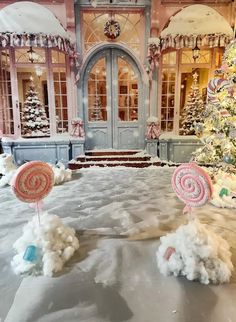 two candy lollipops in front of a decorated christmas tree and storefront