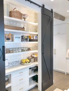 an open pantry door in a kitchen with white cabinets