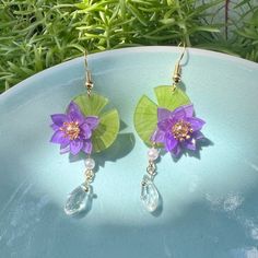 Immerse yourself in the enchanting world of Japanese aesthetics with these Purple Water Lily Lotus Flower with Crystal Drops Japanese Earrings. Handcrafted with utmost care and attention to detail, these earrings are a delightful blend of elegance, charm, and kawaii aesthetics. The centerpiece of these handmade earrings is the exquisite purple water lily lotus flower. Inspired by the beauty of water lily pond, the intricate detailing of the petals captures the essence of grace and tranquility. T Lily Pad Earrings, Water Lily Earrings, Water Lily Jewelry, Purple Water Lily, Purple Lilies, Japanese Earrings, Purple Water, Water Lily Pond, Earrings Kawaii