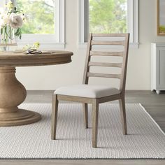 a dining room with a table and chair next to a vase on top of the table