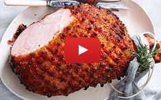 a large piece of meat sitting on top of a white plate next to utensils