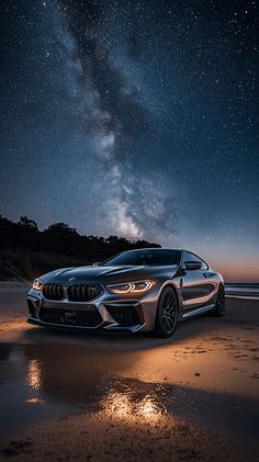 a car parked on top of a sandy beach under a night sky