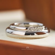 two wedding rings sitting on top of each other