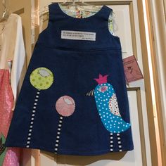 Handmade, Fully-Lined, 100% Cotton, Denim Jumper Dress With Funky Appliques Of A Bird And Flowers. Looks Cute Alone Or Over A Little Tee And Leggings. Back Of Neck To Bottom Of Skirt 19.5" Whimsical Fitted Cotton Dress, Blue Cotton Patchwork Dress, Playful Cotton Dresses For Playtime, Cute Blue Cotton Dress, Playful Blue Dress For Playtime, Playful Blue Dresses For Playtime, Fitted Fun Blue Dress, Fun Fitted Blue Dress, Playful Fitted Patchwork Dresses