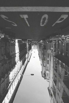 the reflection of buildings in the water is seen from below, as if looking down at them