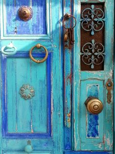 an old blue door with gold hardware and knobs