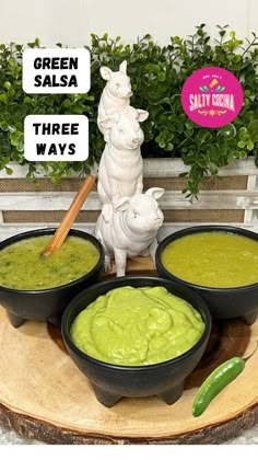 three bowls of guacamole and a small statue