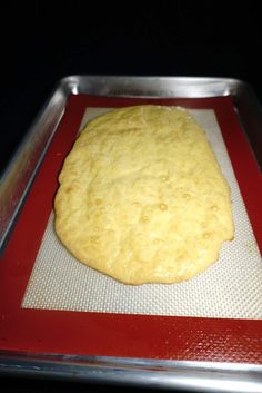 an uncooked pizza dough on a baking sheet