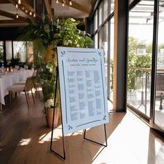 a sign in the middle of a room with tables and chairs around it that is set up for an event