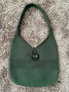 a green purse sitting on top of a carpet