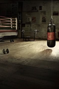 a boxing ring with two punching gloves hanging from the ceiling and other equipment on the floor