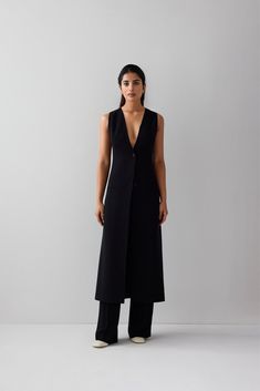 A touch of sophistication to your wardrobe with our idée long vest. Made from high-quality puerto rico fabric and lined for ultimate comfort, this contemporary vest features two buttons, two side pockets, and a single back vent. The versatile design and casual aesthetic make it perfect for everyday wear, while the sleek fit and formal aesthetic make it suitable for any formal occasion. You can even wear it outdoors for an added touch of style. The blend of polyester and viscose ensures you stay Sleeveless Vest With Button Closure For Business Casual, Business Casual Sleeveless Vest With Button Closure, Elegant Single Breasted V-neck Vest, Elegant Single-breasted V-neck Vest, Sleeveless Tailored Blazer With Pockets, Sleeveless Blazer With Pockets For Work, Sleeveless Vest With Hidden Buttons For Office, Versatile Fitted Vest For Workwear, Sleeveless Single Button Blazer For Work