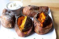 baked potatoes on a plate with dip in the middle