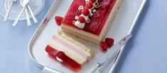 two slices of cake sitting on top of a tray next to silver utensils