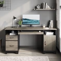 a desk with a computer on it in front of a wall mounted bookcase and shelves