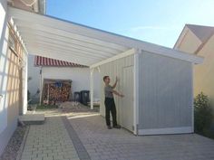 a man standing in front of a white shed