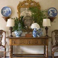 an ornate table with blue and white vases on it