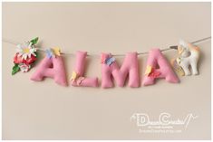 the word alma is made out of felt and decorated with flowers, leaves and unicorns